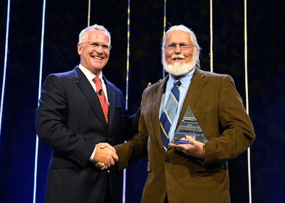 Landstar President and CEO Jim Gattoni, left, presents owner-operator Art Trezise, right, with the fleet’s lifetime achievement award. (Image Courtesy of Landstar)