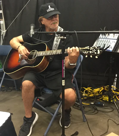 Dennis McKay, who with his wife Leslie, make up the McKay Project plays guitar at their booth. The couple is from Columbus, Mississippi.