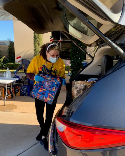 A Love’s volunteer loads supplies into the car of a military family