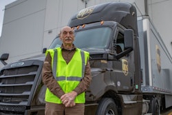 Truck driver standing in front of UPS tractor-trailer