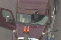 Semi truck with tire smashed through its windshield
