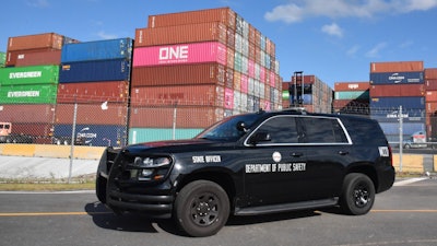 Police car in front of shipping containers