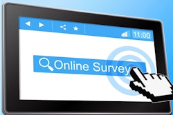 Hand touching 'online survey' on computer screen