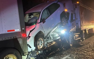 Two cars crashed between 2 tractor-trailers