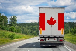 Canada flag on the back of big rig trailer on the highway