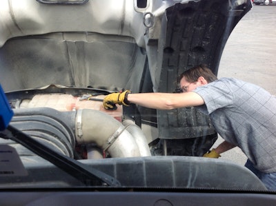 Technician working on truck engine