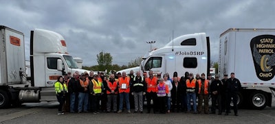 Group of drivers and police officers with two tractor-trailers
