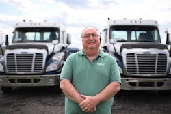 College CDL instructor Dennis Dyer in front of two trucks