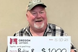 Oregon truck driver with big check from the Oregon Lottery