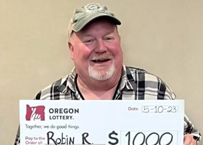 Oregon truck driver with big check from the Oregon Lottery