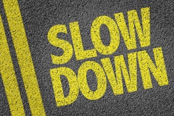'Slow Down' painted on pavement