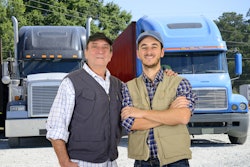 Older driver and young driver in front of trucks