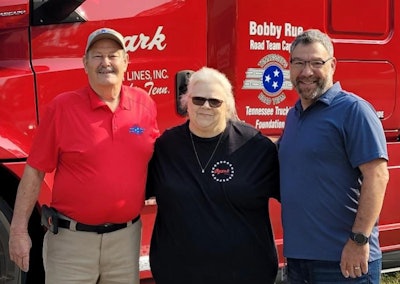 Three people in front of Ozark Motor Lines truck