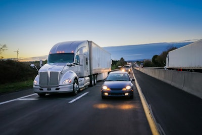 Tractor-trailers on highway with cars