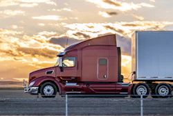 Tractor-trailer on highway at sunset