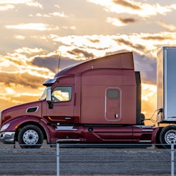 Tractor-trailer on highway at sunset