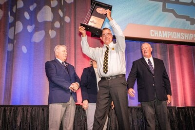 Grand champion driver holds trophy aloft
