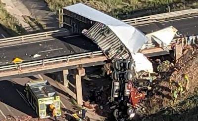 Th cab of the tractor-trailer involved in a crash in Colorado dangled of an I-25 bridge