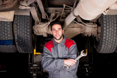 Diesel technician under a truck
