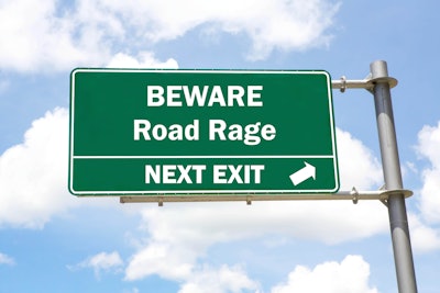 Green highway sign that says 'Beware Road Rage Next Exit'