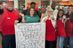 TA employees hold 'Team Battle Creek' sign