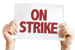 Hands holding up 'On Strike' sign