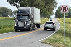 Tractor-trailer on rural road with 'No Truck' sign