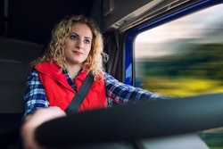 WOMAN TRUCK DRIVER AT THE WHEEL