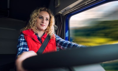 WOMAN TRUCK DRIVER AT THE WHEEL