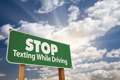 'Stop Texting While Driving' in white on green highway sign
