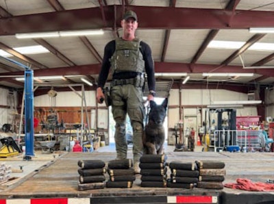 Sgt. Randy Thumann and Kolt with the cocaine they found in the axles of a tractor-trailer