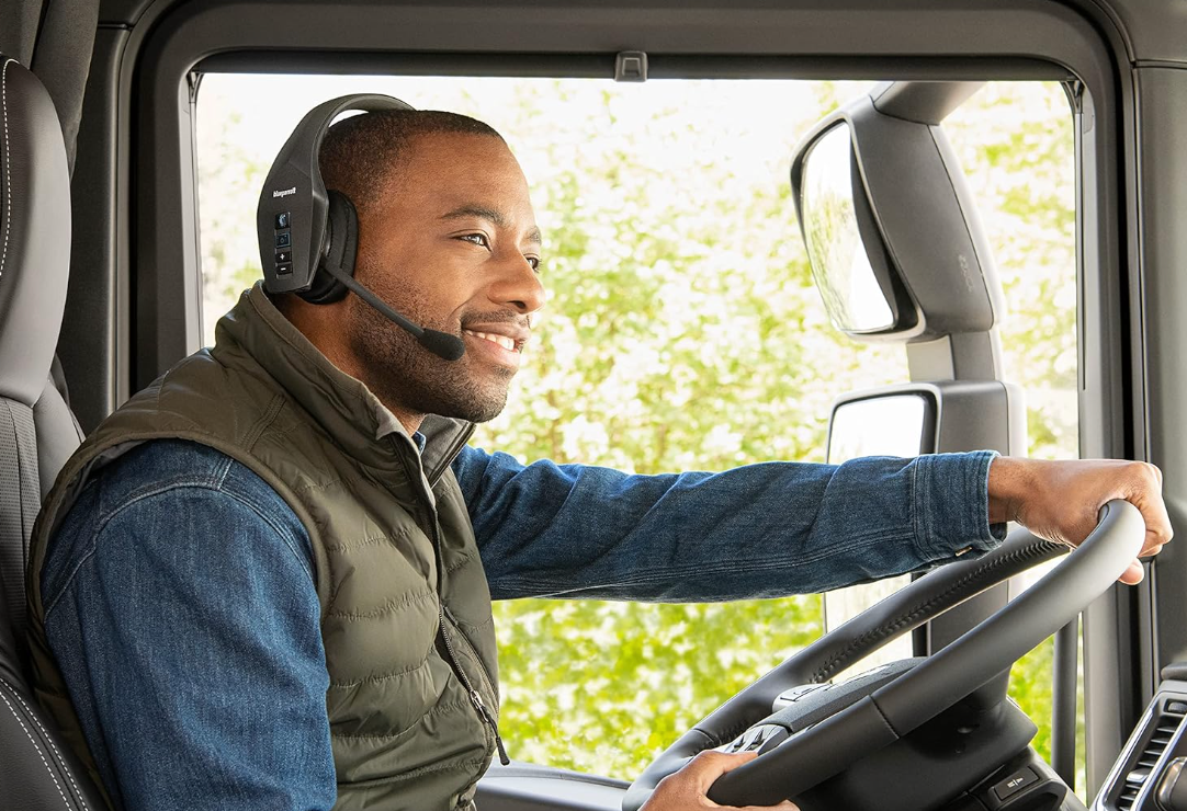 Truck driver at the wheel wearing headset