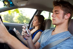Two people using smartphones in car
