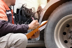 Man holding clipboard inspects truck