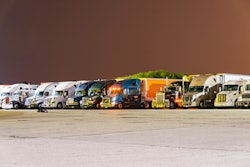 Line of parked big rigs at night