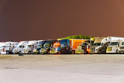 Line of parked big rigs at night