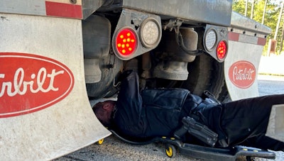 Officer inspecting truck brakes