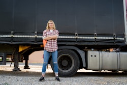 Woman truck driver in front of her tractor-trailer