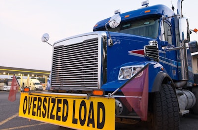 Big rig with 'Oversized Load' sign on front