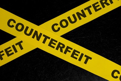 'Counterfeit' on yellow tape on black background