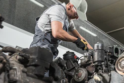 Technician works on truck engine