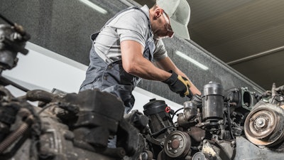 Technician works on truck engine