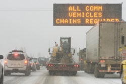 CVhain warning sign on snowy highway