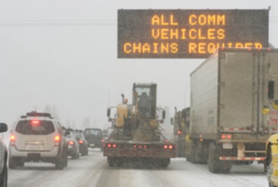 CVhain warning sign on snowy highway