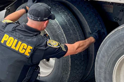 Officer inspecting big rig tires