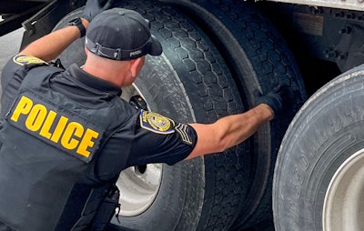 Officer inspecting big rig tires