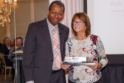Lori Krumpols accepts her husband's 2024 Driver of the Year award from Wheaton's Director of Traffic, Doug Robinson
