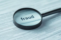 Magnifying glass examining document with 'fraud' text highlighted, representing fraud detection and investigation