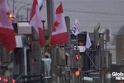 Canadian flag-bearing trucks lined up in foggy conditions during convoy demonstration
