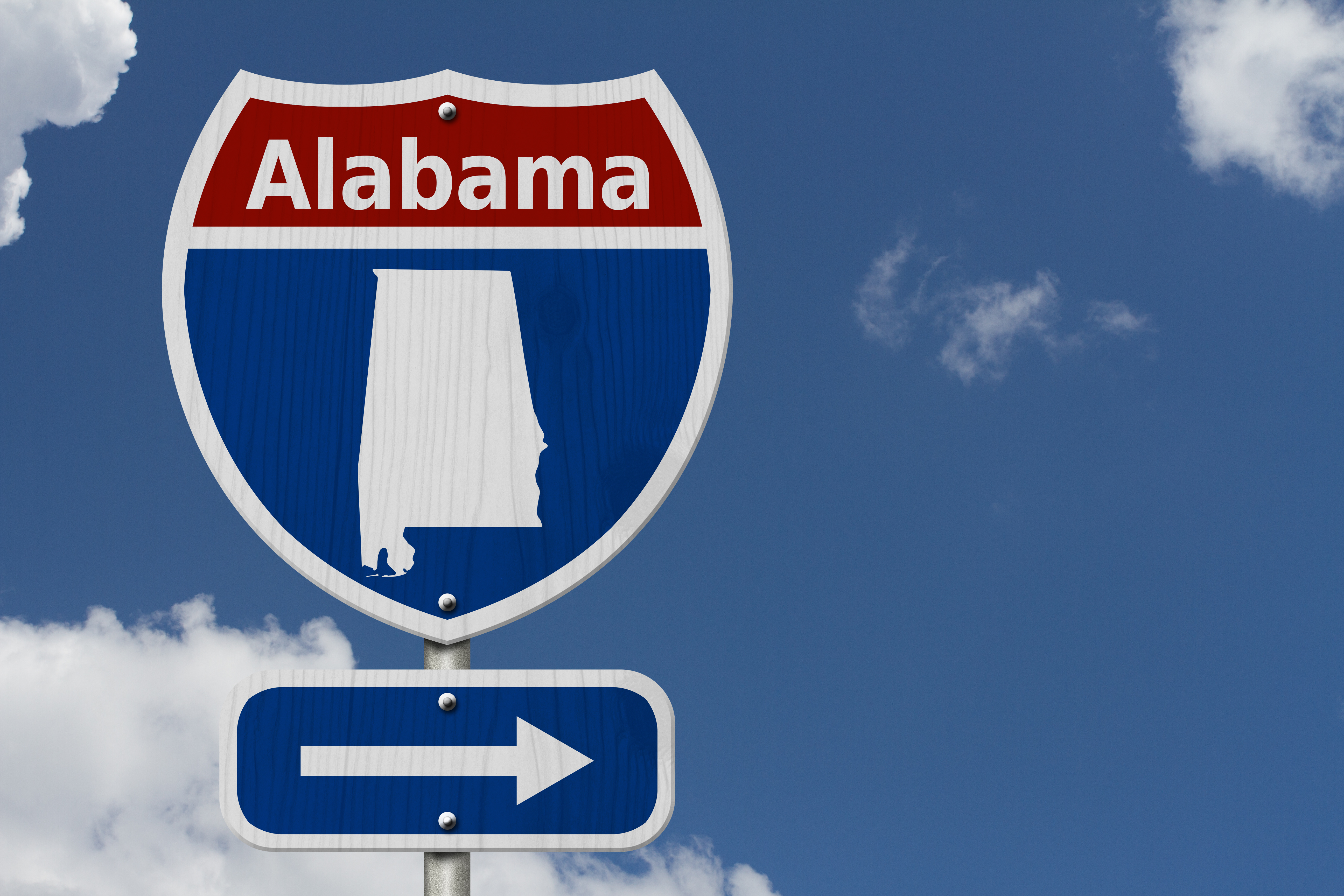 Alabama interstate highway sign with directional arrow pointing right against blue sky